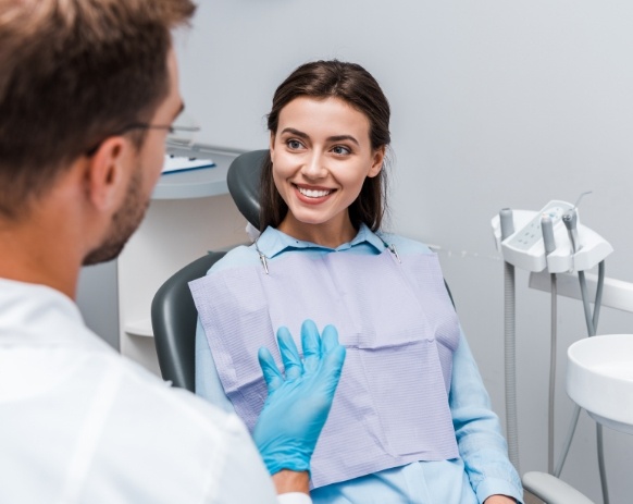 Woman in dental chair smiling at dentist