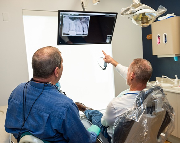 Woman in dental chair smiling at dentist