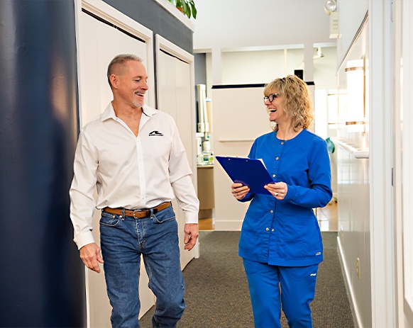 Two dental patients checking in at dental office reception desk