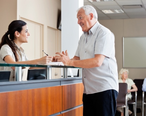 Dental team member and dentistry patient discussing the cost of dental implants