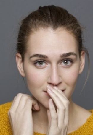 Woman covering her mouth before replacing missing teeth