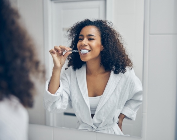 Woman brushing teeth at home