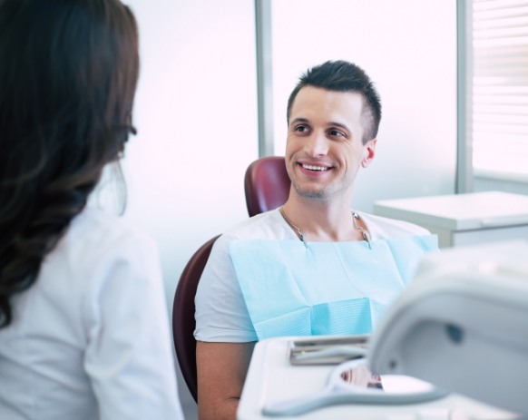 Dental patient talking to dentistry team member after metal free dental restoration
