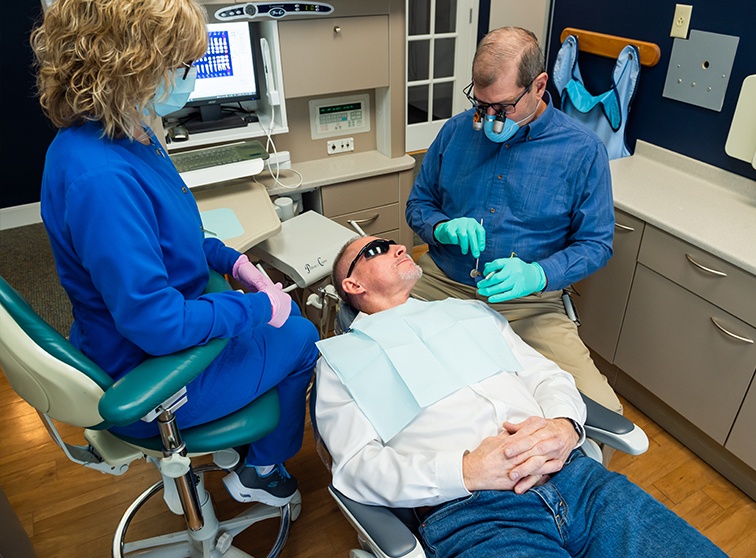 Dentist and dental team member treating dental patient in Lancaster