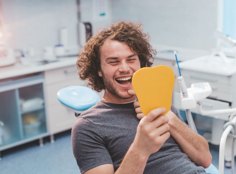 Man looking at smile in the mirror