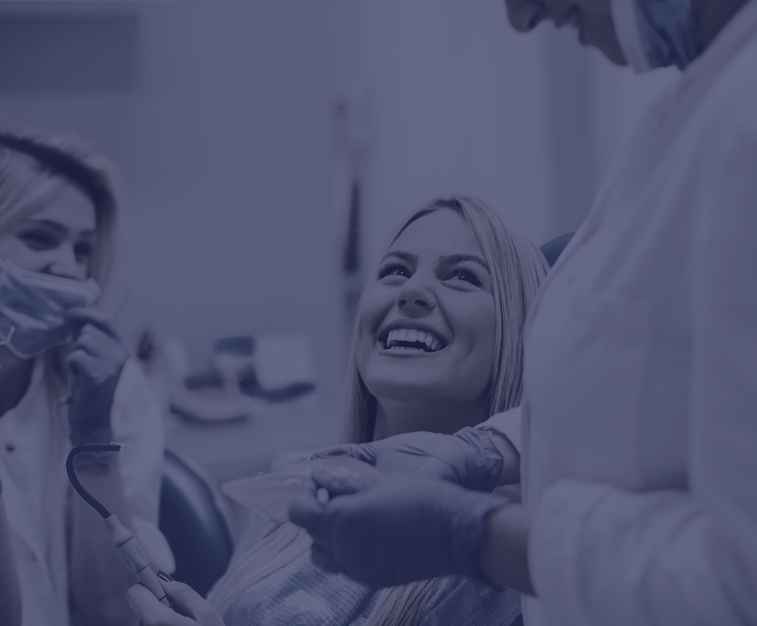 Woman in dental chair smiling at her dentist