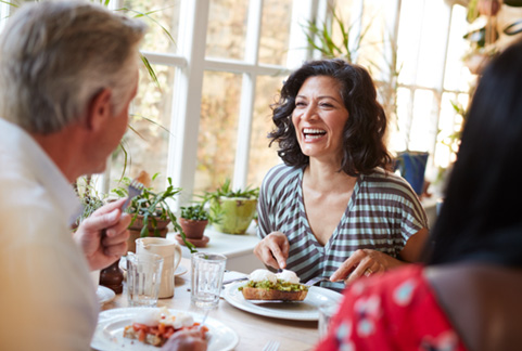 People laugh while eating brunch