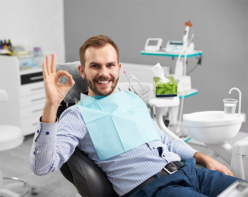 Male dental patient giving okay sign after smile makeover in Lancaster, PA