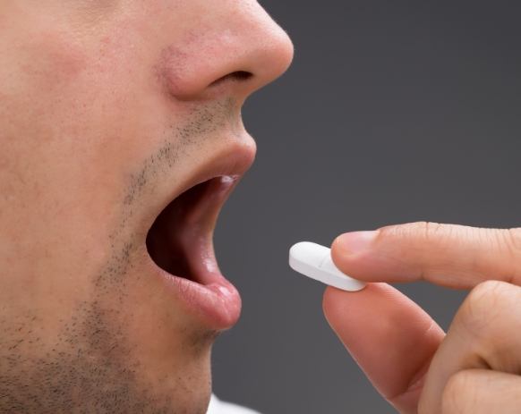 Dental patient taking an oral conscious dental sedation pill