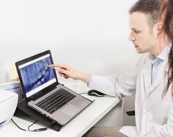 Dental team members looking at image on computer screen