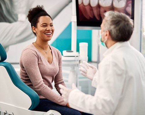 A woman discussing TMJ disorder with a dentist