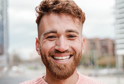 Bearded man outside smiling in the city