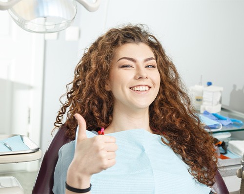 Woman with curly hair giving thumbs up