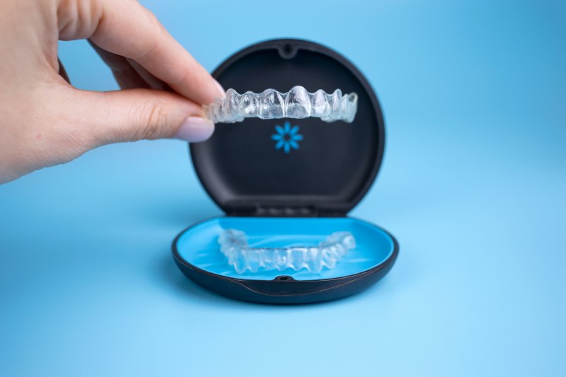 A woman placing her Invisalign trays in a storage case