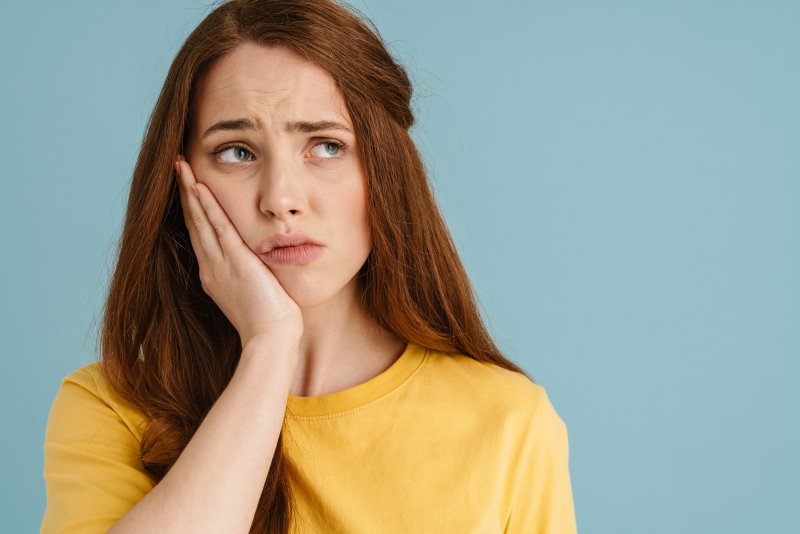 Patient holding their cheek due to facial swelling