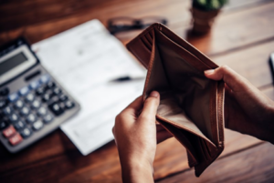 Person opening their wallet to reveal that it’s empty